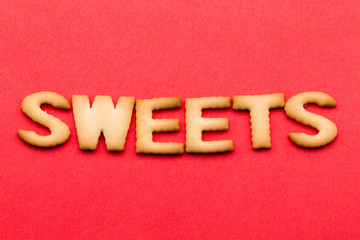 Wall Mural - Word sweets cookie over the red background