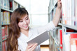 © zhu difeng - Asian beautiful female student using tablet in library