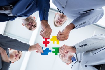 Wall Mural - Business colleagues holding piece of puzzle