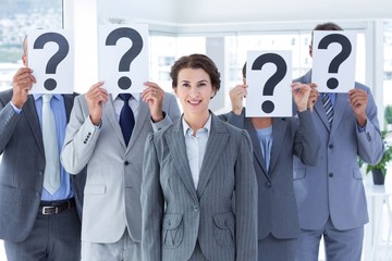 Wall Mural - Business colleagues hiding their face with question mark sign