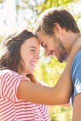 Cute coupe smiling at each other in park 