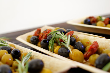 black and green olives, herbs, sun-dried tomatoes in an oblong d