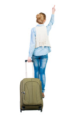 Wall Mural - back view of walking  woman  with suitcase pointing. beautiful girl in motion.