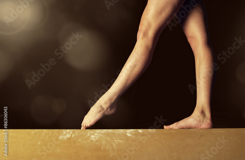 Fotomural Cerrar la vista de las piernas de un gimnasta en una barra de equilibrio