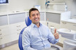 © Syda Productions - happy man showing thumbs up at dental clinic