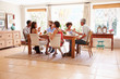 © Monkey Business - Friends sitting at a table talking during a dinner party