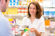 © Production Perig - Attractive pharmacist taking healt insurance card