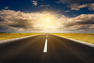 Driving on an open asphalt road at sunset