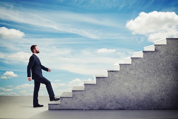 Wall Mural - man walking up stairs over blue sky