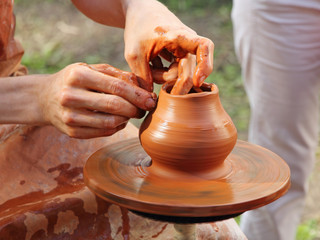 Wall Mural - Potter makes on pottery wheel clay pot.