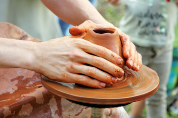 Wall Mural - Potter hands on pottery wheel clay pot.