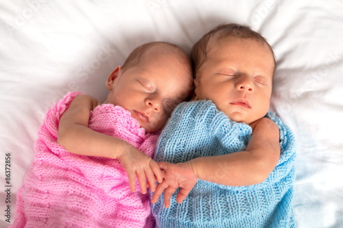 Fototapeta Newborn twins sleeping in cuddle together