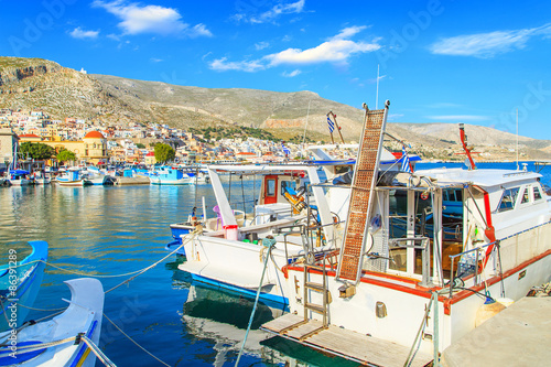 Fotografia  Colorful boats over clear water in peaceful Greek bay, Greece