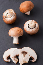 Sliced And Whole Chestnut Mushrooms On Background Of Dark Slate.