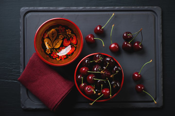 Wall Mural - Top view of a basalt dish with fresh sweet cherries, studio shot