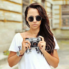 Beautiful girl photographer with old camera