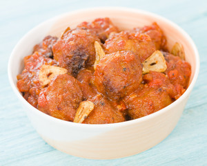 Wall Mural - Albondigas Guisadas - Meatballs in tomato sauce with garlic slivers and thyme leaves.
