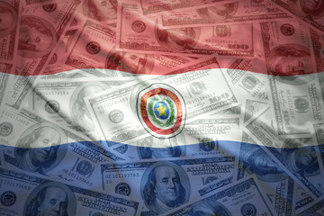colorful waving paraguayan flag on a american dollar money background