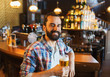 © Syda Productions - happy man drinking beer at bar or pub