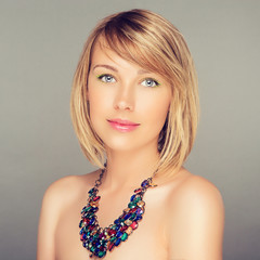 Portrait of Beautiful Cute Woman with Blonde Hair and a Necklace of Precious Stones. Close Up