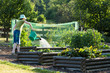 woman watering vegetable in the country organic sustainable garden