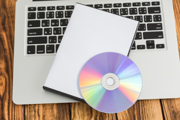 Blank compact disc with cover on laptop keyboard