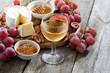 glass of cold white wine and snacks on a wooden background