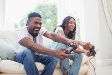 Happy Couple On The Couch Playing Video Games