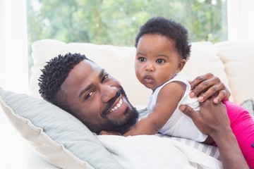 Wall Mural - Happy father with baby girl on couch