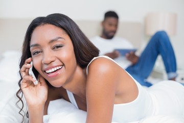 Wall Mural - Relaxed couple using technology on bed