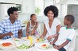 © WavebreakMediaMicro - Happy family sitting down to dinner together