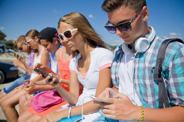 Wall Mural - group of teenagers spending time together with gadgets