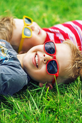 Fototapete - Cheerful brothers lying on the lawn
