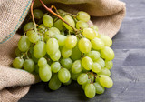 Fototapeta Tęcza - bunch green grapes on wooden background