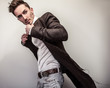 © Unique Vision - Elegant young handsome man in long stylish coat. Studio fashion portrait.