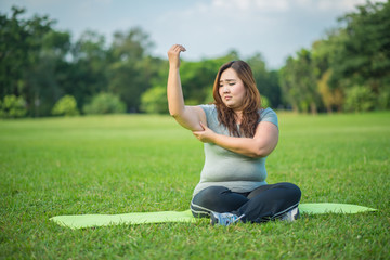 fatty woman checking her fat arm in the garden