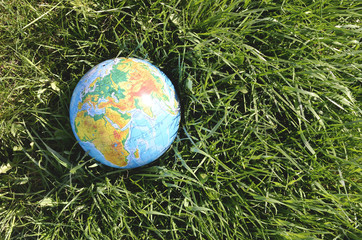 Globe lies on green grass. Concept - Earth Day.