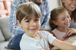 © goodluz - Portrait of smiling 4-year-old boy, family in background