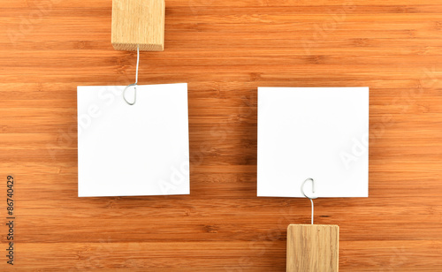 Two Paper Notes With Holders In Different Directions On Wood