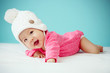 © DN6 - Little baby in knit winter clothing closing face with knitted be