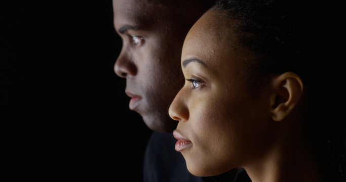 Wall Mural -  - Dramatic side view of two young African American people on black background