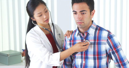 Chinese doctor listening to Mexican patient's breathing