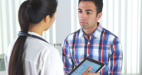 Wall Mural - Chinese doctor talking to patient and taking notes