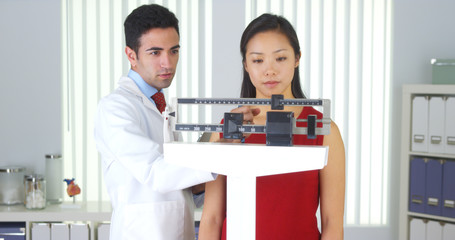 Wall Mural - Mexican doctor weighing Chinese patient