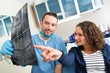 © Production Perig - Young attractive dentist showing x-ray to patient