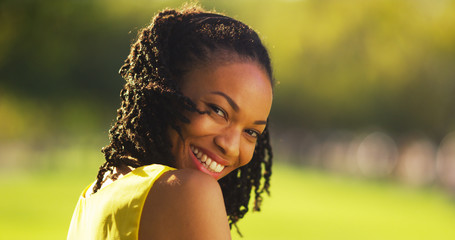 Wall Mural - Cute black woman smiling in a park