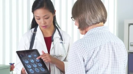 Wall Mural - Chinese doctor talking to patient about xrays