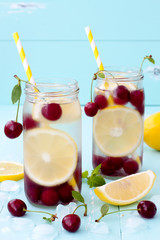 Wall Mural - Detox fruit infused flavored water with cherry, lemon and mint. Refreshing summer homemade cocktail. Clean eating