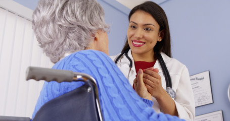 Elderly patient thanking Mexican woman doctor