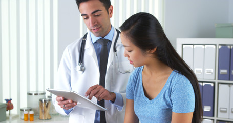 Wall Mural - Asian patient talking with her doctor about her test results